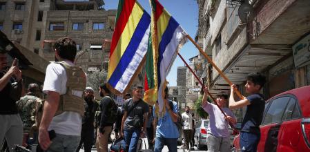 Banderas de la minoría drusa y milicianos armados en Jaramana, suburbio de Damasco, ayer tras los disturbios que causaron cuatro muertos