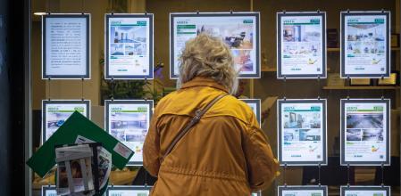 Una persona consulta los anuncios de compraventa de vivienda en una inmobiliaria&nbsp;