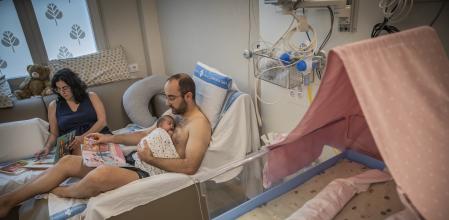 Una pareja con su bebé en la uci de neonatos del Vall d’Hebron, donde se fomenta la lectura en voz alta