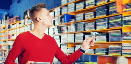 Chico mirando una estantería de videojuegos.