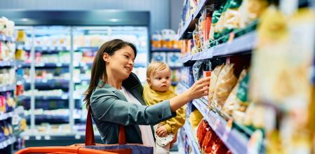 Una madre compra en un supermercado comida para su bebé
