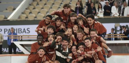 Spain's Carlos Alcaraz celebrates with ball boys and girls after winning the final match of the French Tennis Open against Italy's Jannik Sinner at the Roland-Garros stadium in Paris, Sunday, June 8, 2025. (AP Photo/Thibault Camus)