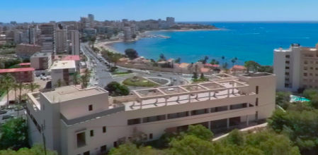 En primer término, el edificio abandonado durante 17 años que se convertirá en hotel frente a la playa de La Albufereta en Alicante&nbsp;