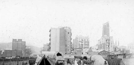 Al fondo la Sagrada Familia en construcción con Gaudí en vida, hacia los años 1924-1925, y, en primer plano, las condiciones de vida en los alrededores en aquella época.