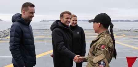 Macron, junto a la primera ministra danesa y el jefe del gobierno autónomo groenlandés, saluda a una militar en Nuuk, la capital de la isla ártica&nbsp;&nbsp;