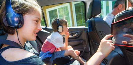 Unos niños disfrutan de contenido audiovisual mientras viajan