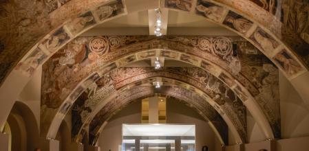 Varias personas observan las pinturas murales del Monasterio de Sijena expuestas en el Museu Nacional d’Art de Catalunya (MNAC)