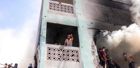 Un grupo de palestinos intentan extinguir el humo en un edificio bombardeado&nbsp;