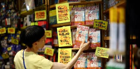 Una dependienta coloca el manga “El futuro que vi” en el expositor de una librería de Tokio&nbsp;