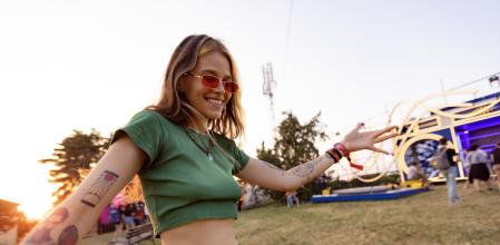 Mujer joven baila y disfruta de la música antes de un concierto.&nbsp;