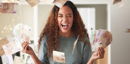 Una mujer celebra la inyección de dinero en efectivo gracias al regalo promocional por domiciliar su nómina