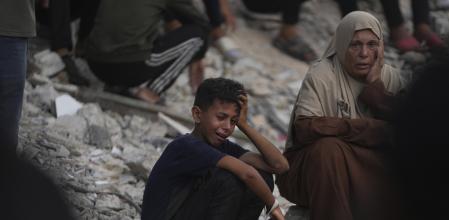 Palestinos lloran durante el funeral por las personas que murieron mientras intentaban llegar a los camiones de ayuda que entraban en Gaza.