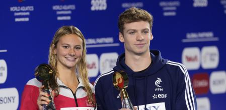 Leon Marchand of France, right, and Summer McIntosh of Canada pose with their trophies at the World Aquatics Championships in Singapore, Sunday, Aug. 3, 2025. (AP Photo/Vincent Thian)