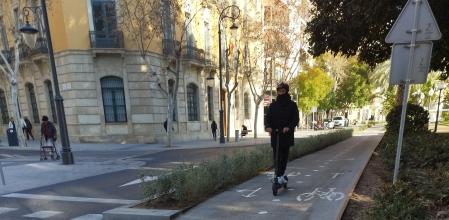 Un joven circula correctamente en patinete por el carril bici del Paseo de Canalejas de Alicante.