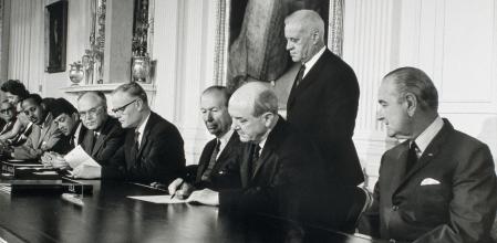El presidente de Estados Unidos Lyndon B. Johnson (derecha) observa cómo el secretario de Estado Dean Rusk firma el Tratado de No Proliferación Nuclear en 1968