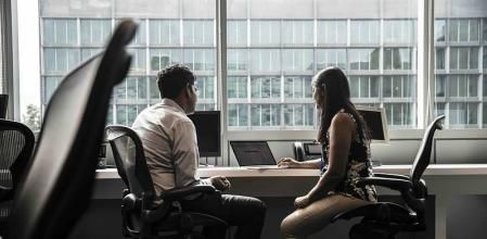 Dos empleados en la oficina usando IA