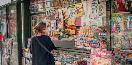 Mujer acudiendo a un quiosco a comprar su séquito de revistas mensuales