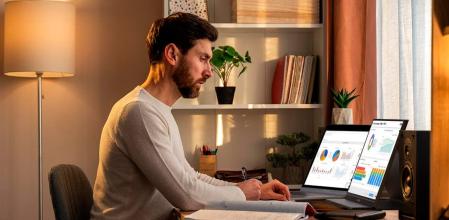 Hombre trabajando en un escritorio con dos pantallas