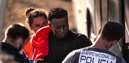 La policía atiende a un migrante.