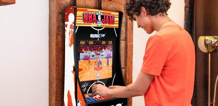 Joven jugando con la máquina de arcade NBA Jam