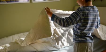 Niño haciendo la cama