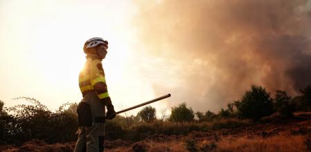 Un bombero trata de apagar un fuego