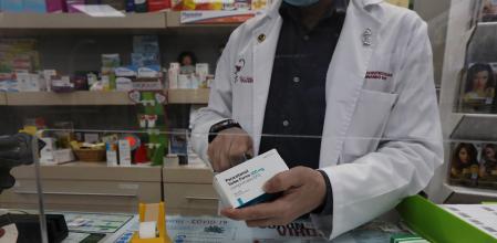 Un farmacéutico recorta el código de barras de una caja de Paracetamol en su farmacia durante el segundo mes de confinamiento, en Madrid (España) a 20 de abril de 2020.