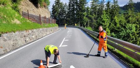 Personal pintando la señalización en una carretera de Austria