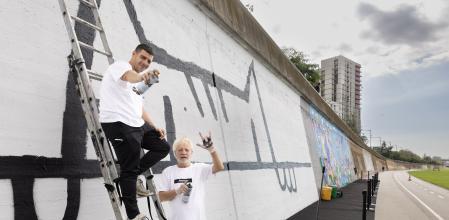Javier Mariscal (derecha) y el artista Kamil, en el mural de Cobi en el Besart de Santa Coloma