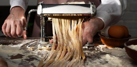 Un hombre prepara pasta fresca para toda la familia en casa