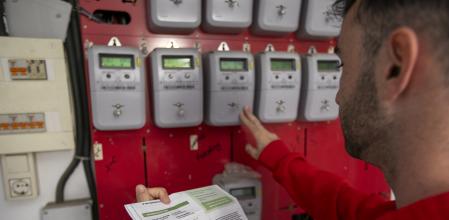 GASTOS DOMÉSTICOS Y ECONOMÍA FAMILIAR. SUBIDA DE LA LUZ. UN HOMBRE COMPRUEBA LA FACTURA DE LA LUZ JUNTO A LOS CONTADORES DE LA DE UNA COMUNIDAD DE VECINOS.