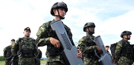 Colombian soldiers hold anti-drone weapons during the activation of the first unmanned aircraft battalion at the military base in Tolemaida, Colombia, on October 10, 2025. The Colombian army unveiled its first drone battalion on October 10, 2025, designed to attack and defend against illegal armed groups such as guerrillas, which use this type of aircraft to target both military personnel and civilians in a tactic that has transformed the armed conflict. (Photo by Raul ARBOLEDA / AFP)