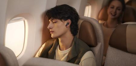 Un joven escucha música con los auriculares HUAWEI FREEBUDS 6i mientras viaja en avión