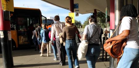 Usuarios subierndo a un bus alternativo en la estación de Fabra i Puig en Barcelona.