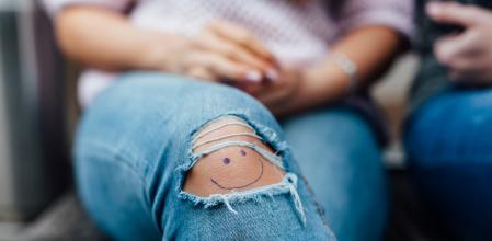 Una joven con un pantalón tejano roto.