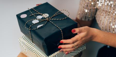 Una mujer con varias cajas de regalos en la mano