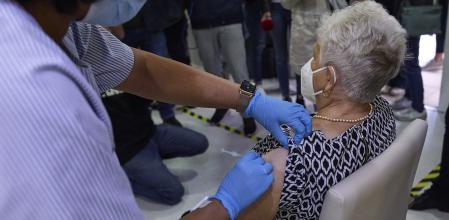 Una sanitaria vacuna a una mujer de la covid