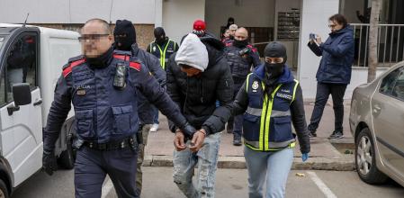 Mossos d'Esquadra y Policía Nacional trasladan a uno de los detenidos durante la operación de este martes contra los Trinitarios