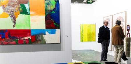 Dos hombres observan las obras expuestas el día de la inauguración de ARCO Madrid 2024, en Feria de Madrid 