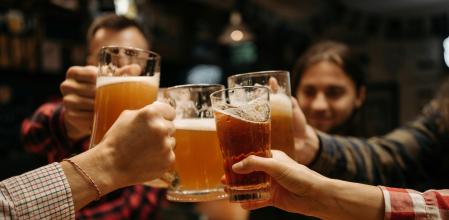 Un grupo de amigos brinda con cerveza en un bar