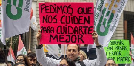 Manifestante con una pancarta con el lema 'Pedimos que nos cuiden para cuidarte mejor' durante una manifestación en 2025.&nbsp;