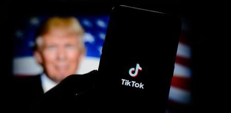En esta ilustración fotográfica, el logotipo de la aplicación TikTok aparece en un teléfono inteligente con el presidente de los Estados Unidos, Donald Trump.