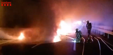 Los Bombers de la Generalitat de Catalunya trabajan en la extinción del fuego tras incendiarse un camión en la AP-7