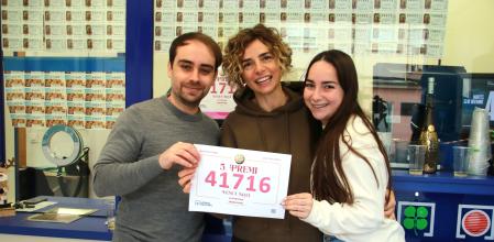 Tere Albaigès, propietaria de la administración número 19 de Tarragona, junto a dos de sus trabajadores, mostrando el quinto premio de la Lotería de Navidad 2025.