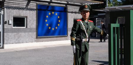 Un policía paramilitar chino vigila la entrada a la delegación de la Unión Europea en Pekín 