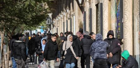 People walk past stores as the value of the Iranian Rial drops, in Tehran, Iran, December 30, 2025. Majid Asgaripour/WANA (West Asia News Agency) via REUTERS ATTENTION EDITORS - THIS PICTURE WAS PROVIDED BY A THIRD PARTY