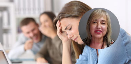 Trabajadores riéndose de una compañera de trabajo en la oficina