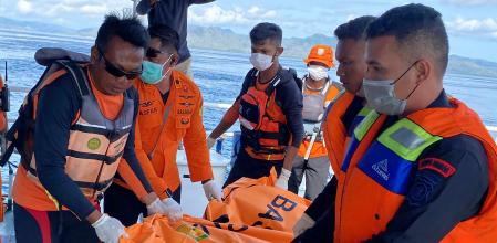 This handout picture taken and released on January 4, 2026 by Indonesia's National Search and Resque Agency (BASARNAS) shows rescue personnel carrying a body bag containing the remains of missing Spanish man Fernando Martin Carreras, from waters off Labuan Bajo in East Nusa Tenggara. Rescuers retrieved on January 4 the body of a Spanish man who had been missing since a tourist boat sank in rough seas off eastern Indonesia more than a week ago, an official said. (Photo by Handout / INDONESIA'S NATIONAL SEARCH AND RESCUE AGENCY (BASARNAS) / AFP) / RESTRICTED TO EDITORIAL USE - MANDATORY CREDIT 
