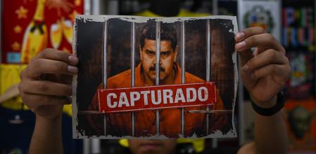 Un hombre muestra una imagen alterada digitalmente del derrocado presidente venezolano Nicolás Maduro