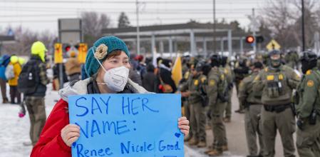 AME3271. MINNEÁPOLIS (ESTADOS UNIDOS), 08/01/2026.- Una persona muestra un cartel a integrantes de Policía que custodian la sede del Servicio de Inmigración y Control de Aduanas (ICE) este jueves, en Mineápolis (EE.UU.). Al menos ocho personas fueron detenidas durante el inicio de la segunda jornada de protestas por la muerte de una mujer estadounidense tras recibir varios disparos por parte de un agente del ICE, confirmaron testigos a EFE. EFE/ Angel Colmenares